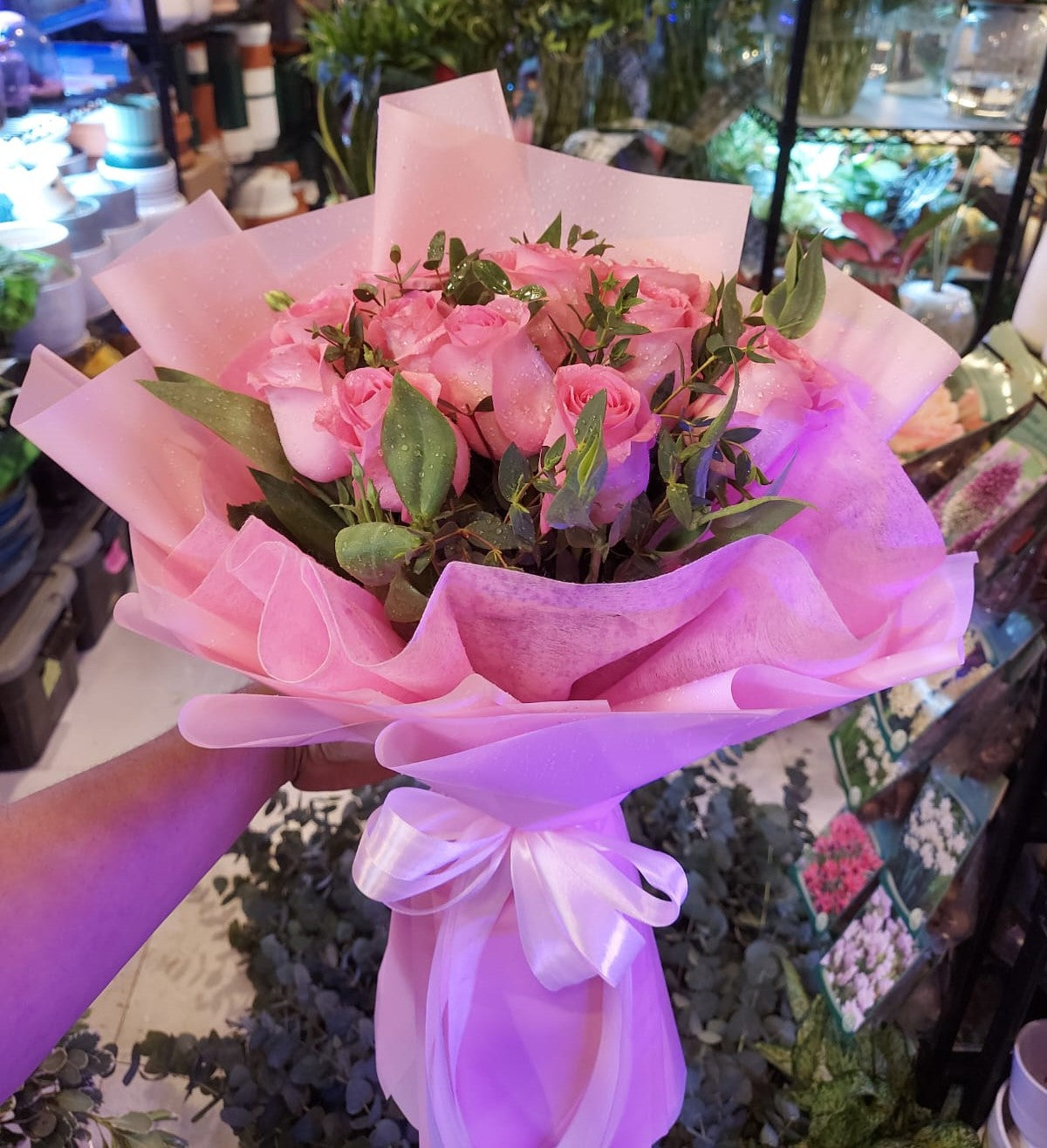 Elegant 12 red roses bouquet with green leaves, wrapped in premium paper and tied with a red ribbon, ready for delivery in Dubai.